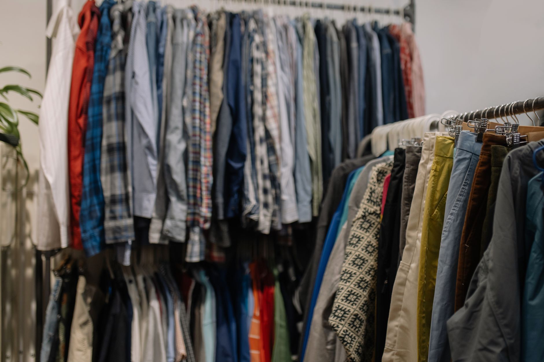 Roupas variadas penduradas em araras de brechó